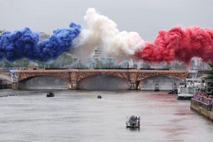 Spettacoli pirotecnici con i colori della bandiera nazionale francese vengono lanciati su un ponte durante la cerimonia di apertura delle Olimpiadi di Parigi il 26 luglio 2024