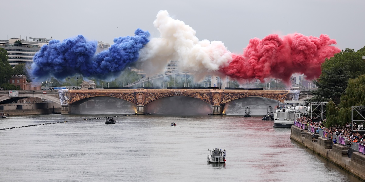 Spettacoli pirotecnici con i colori della bandiera nazionale francese vengono lanciati su un ponte durante la cerimonia di apertura delle Olimpiadi di Parigi il 26 luglio 2024